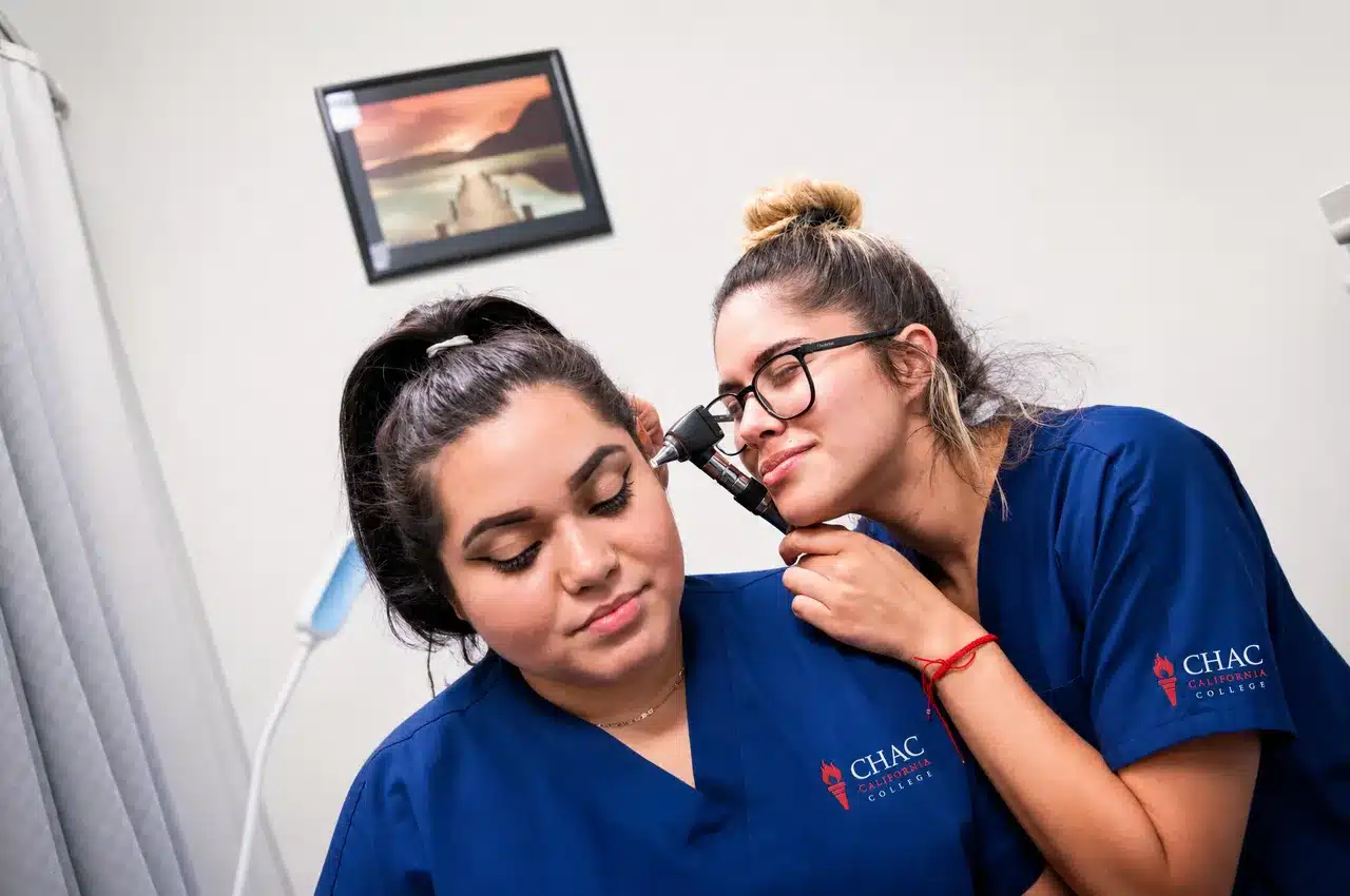 CHAC medical assistant students practicing an ear exam